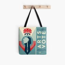 Tote featuring Shepard Fairey's artwork with black straps hanging on a wood hanger